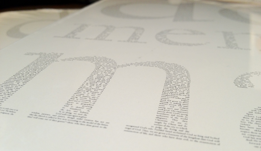 Soft-focused photograph of the printed poster, with some of the lines which comprise the 'm' sharp enough to make out